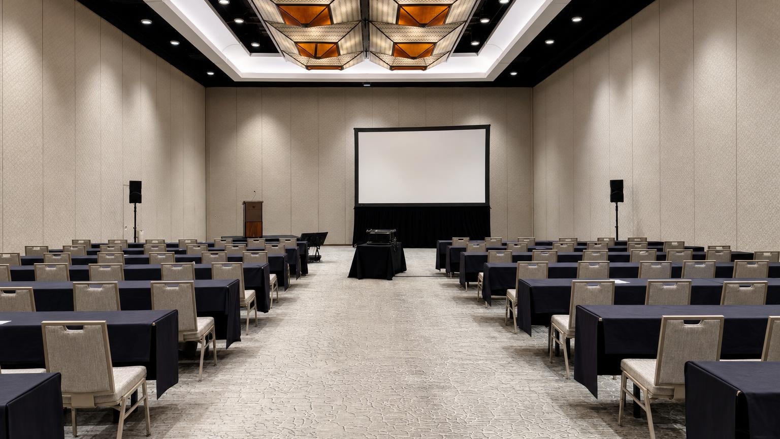 Modest hotel breakout room with projector, screen, and standard ballroom AV