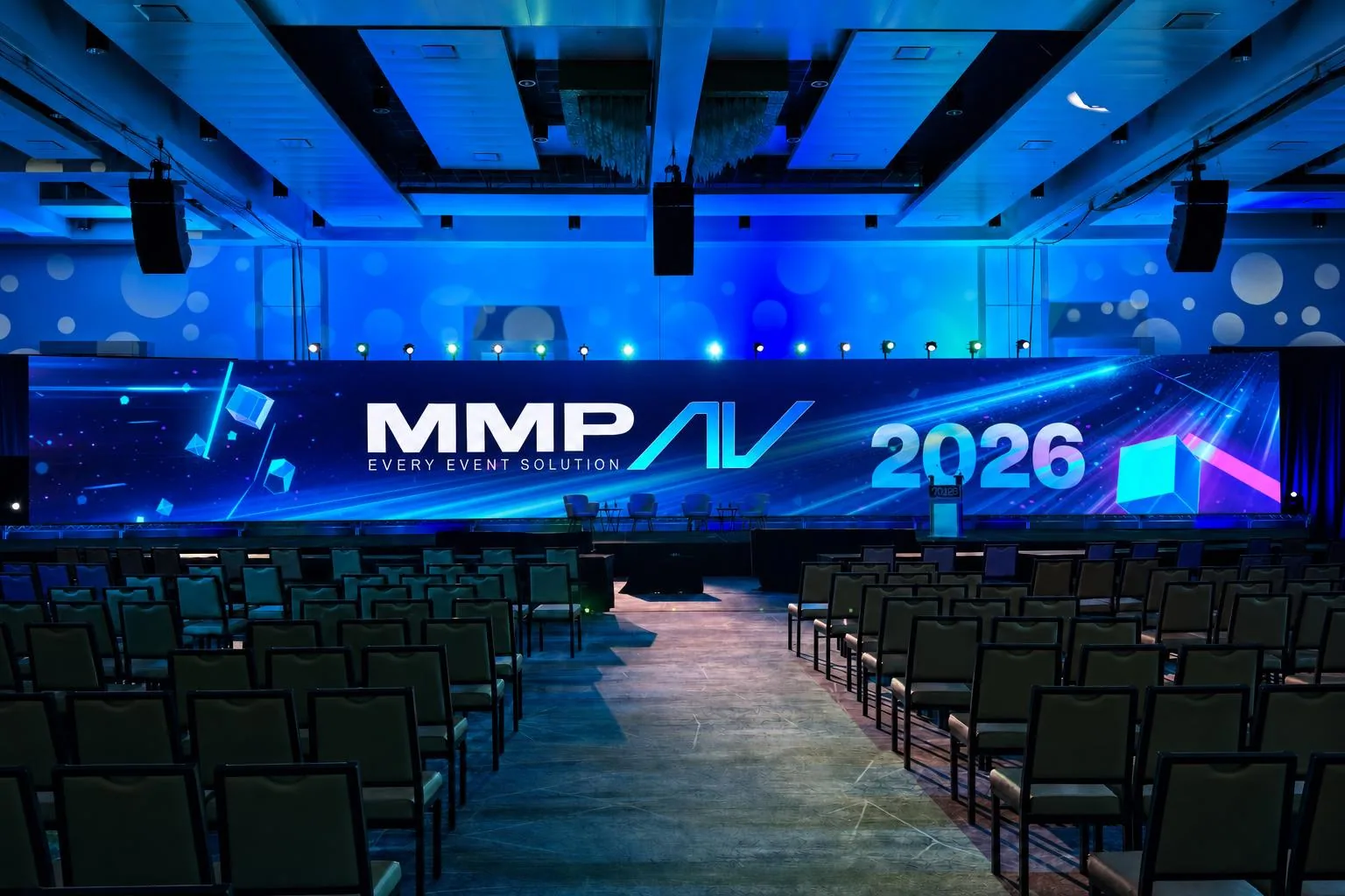Massive curved LED wall displaying flashy cinematic intro motion graphics in a dramatic blue-lit auditorium