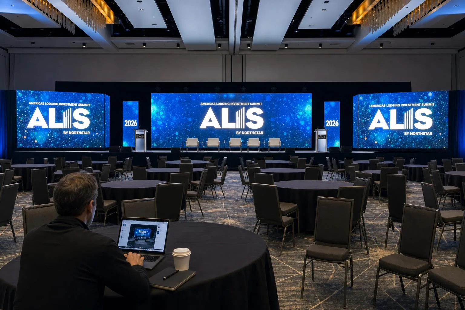 Designer reviewing empty ALIS general session LED wall layout before doors open